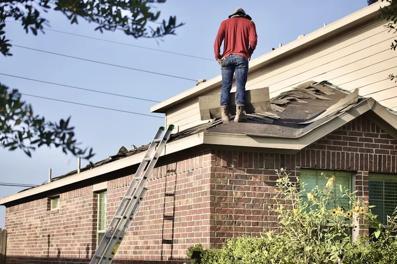 Professional roofer working on a residential roof in Marceline